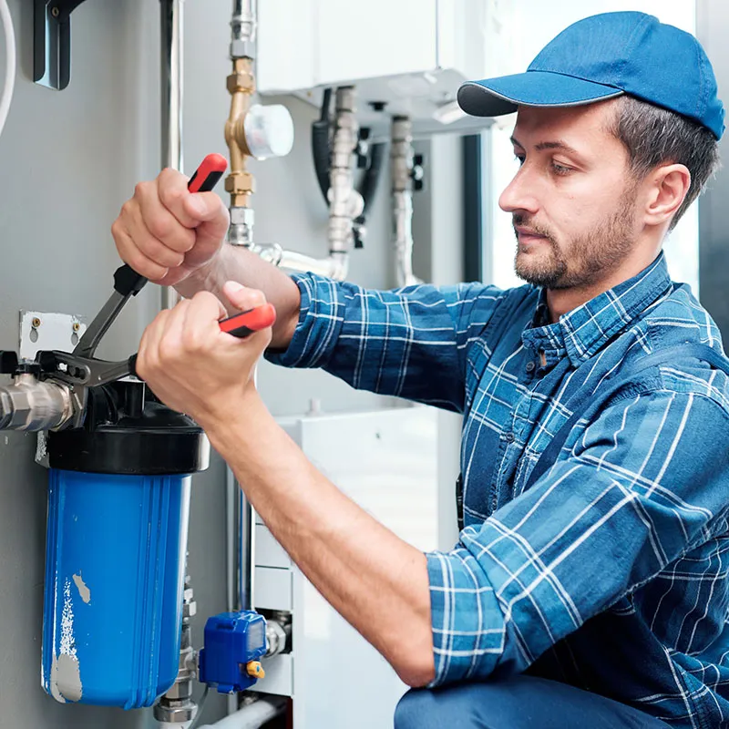 Professional technician installing a water filtration system by Alton Facility Services