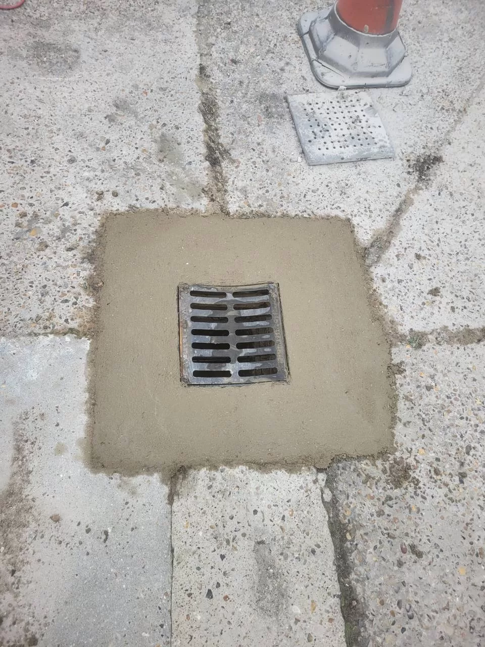 Close-up of new gully lid set in concrete surround