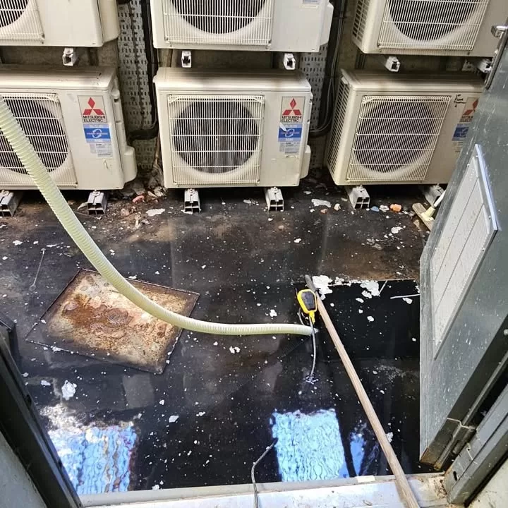 Severe flooding in a pump station chamber with Mitsubishi Electric air conditioning units visible above