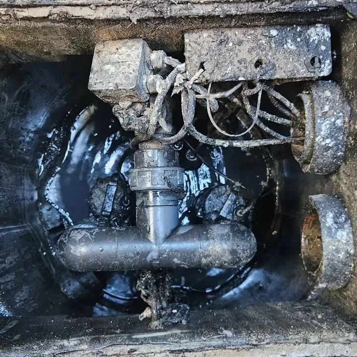 Close-up of a blocked submersible pump and control wiring inside the flooded chamber
